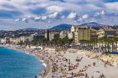 Nice, Fransa - 6 Ekim 2019: Plajda kimliği belirsiz insanlar ve Nice, Fransa 'daki Fransız Riviera' sında gezinti güvertesi. Orada 15 özel ve 20 halk plajı var..