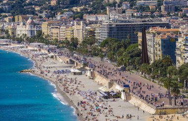 Nice, Fransa - 6 Ekim 2019: Plajda kimliği belirsiz insanlar ve Nice, Fransa 'daki Fransız Riviera' sında gezinti güvertesi. Orada 15 özel ve 20 halk plajı var..