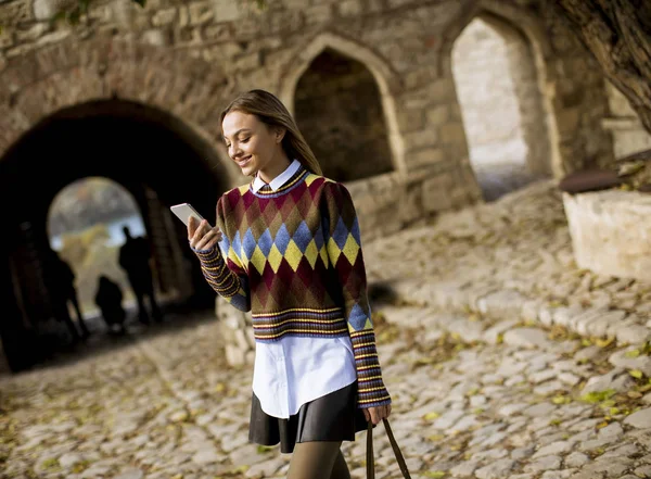 Güz Parkında Yürüyen Cep Telefonu Kullanan Güzel Bir Genç Kadın — Stok fotoğraf