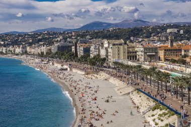 Nice, Fransa - 6 Ekim 2019: Plajda kimliği belirsiz insanlar ve Nice, Fransa 'daki Fransız Riviera' sında gezinti güvertesi. Orada 15 özel ve 20 halk plajı var..