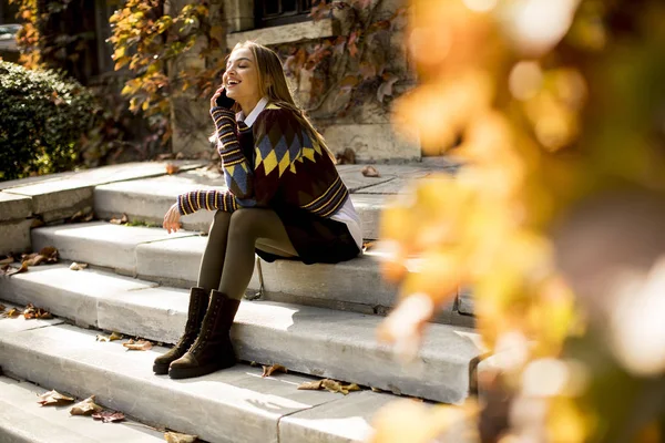 Młoda Kobieta Siedzi Schodach Telefonu Komórkowego Jesienny Park — Zdjęcie stockowe