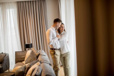 Çağdaş bir dairenin oturma odasında duran genç çift.