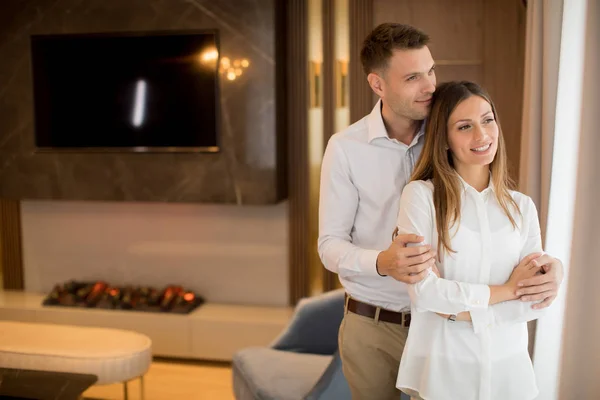在当代公寓的客厅里拥抱的年轻夫妇 — 图库照片
