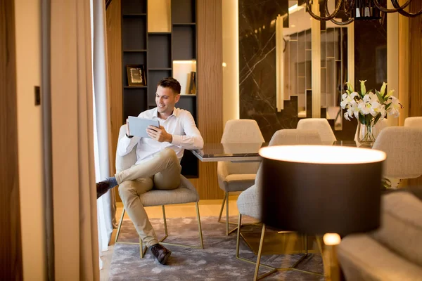 Bonito Jovem Sentado Usando Tablet Digital Apartamento Luxo — Fotografia de Stock