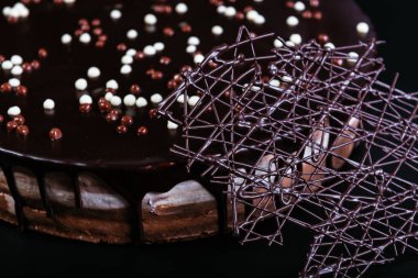 Siyah arka planda beyaz, sütlü ve siyah çikolatalı tart.