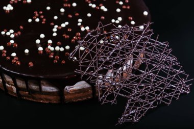 Siyah arka planda beyaz, sütlü ve siyah çikolatalı tart.