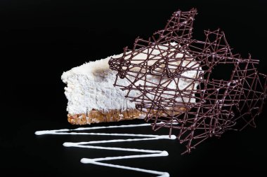 Siyah arka planda beyaz çikolatalı hindistan cevizli tart.