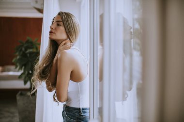Odanın penceresinde tarafından duran genç ve güzel kadın