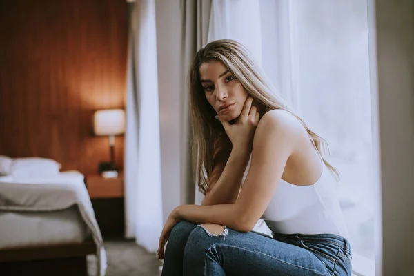 Όμορφη Νεαρή Γυναίκα Κάθεται Δίπλα Στο Παράθυρο Στο Διαμέρισμα — Φωτογραφία Αρχείου