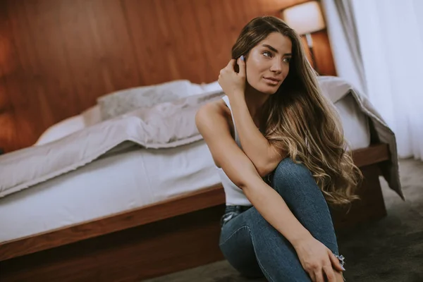 Mooie Jonge Vrouw Stijlvolle Jeans Broek Zittend Aan Bed Thuis — Stockfoto