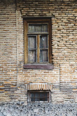 Ahşap pencereli eski tuğla evin yakınına.
