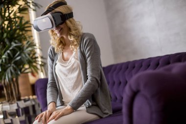 Sanal gerçeklik giyen genç ve güzel kadın odaya gözlükler