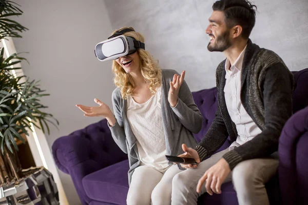 Pareja Joven Sentada Habitación Mientras Joven Lleva Gafas Realidad Virtual — Foto de Stock