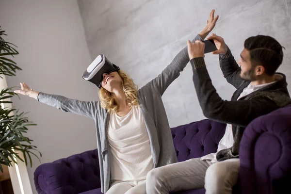 Pareja Joven Sentada Habitación Mientras Joven Lleva Gafas Realidad Virtual — Foto de Stock