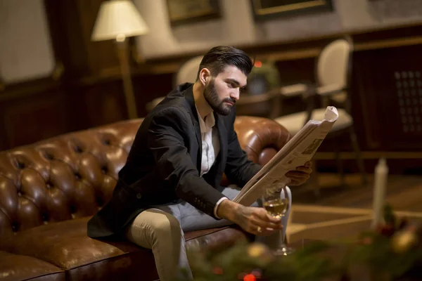Przystojny Młody Biznesmen Pijący Wino Czytający Gazety Biurze — Zdjęcie stockowe