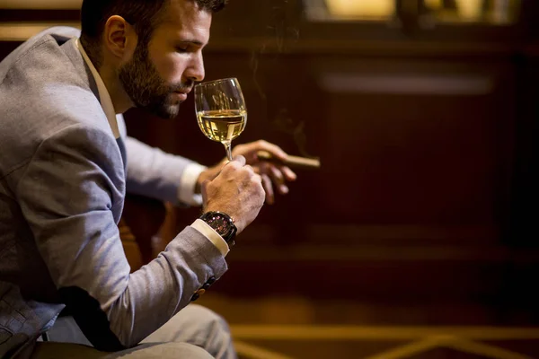 Snygg Ung Man Som Smakar Vitt Vin Och Röker Cigarr — Stockfoto