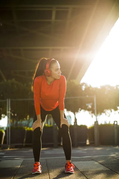 屋外ジョギングの後休憩をして魅力的な若い女性ランナー — ストック写真