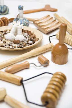 Ahşap tabakta şifalı bitkiler ve ahşap maderoterapi aletleri olan otlar.