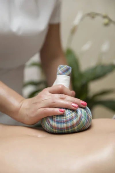 Vrouw Met Een Buik Massage Met Aromatische Kruidenzakken Cosmetische Salon — Stockfoto