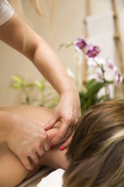 Woman having a neck massage in the salon