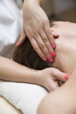 Bir kadının boynuna bir sağlık terapisti tarafından stres giderici bir masaj yaptırması.