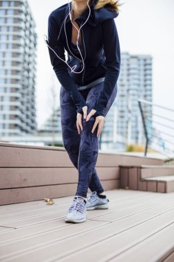 Femanle koşucusu antrenmanda sorun yaşıyor ya da diz ağrısı çekiyor.