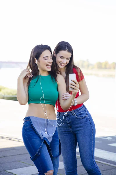 Junge Hübsche Junge Frauen Stehen Mit Kopfhörern Freien Und Hören — Stockfoto