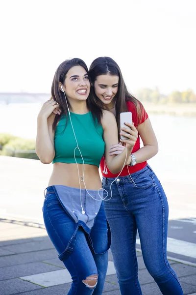 Jovens Mulheres Bonitas Ficar Ouvir Música Com Fones Ouvido Usando — Fotografia de Stock