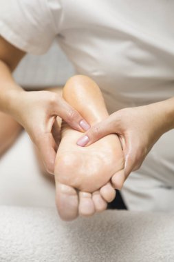 Spa salonunda ayak masajı yaptıran kadının yakın çekimi.