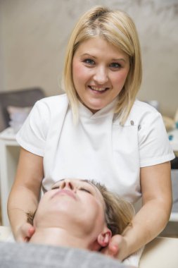 Spa 'da omuz masajı yaparken dinlenen güzel bir genç kadın.