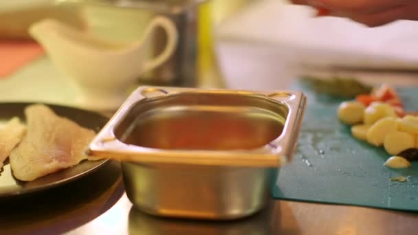 Chef bereidt aardappelen, tomaten, peterselie en olijven op het bord in professionele metalen schotel — Stockvideo