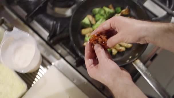 Bereiding van gehakt kalkoenvlees met verse broccoli en gedroogde tomaten in de keuken — Stockvideo