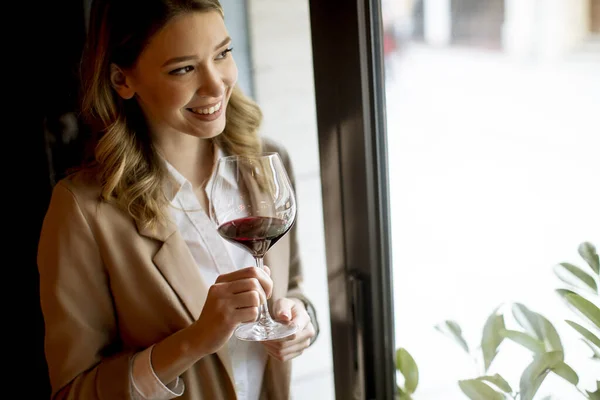 Pencerenin Yanında Duran Kırmızı Şarap Kadehiyle Bekar Güzel Bir Kadın — Stok fotoğraf
