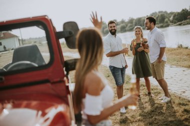 Güneşli sıcak bir yaz gününde açık havada araba ile içme ve eğlenmek gençlerin Grubu