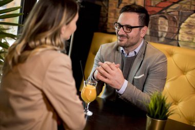 Kafede oturup portakal suyu içen sevimli genç bir çift.