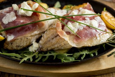 Krem peynirle doldurulmuş çipura ve füme jambon. Tabakta da taze patates ve pırasa var.