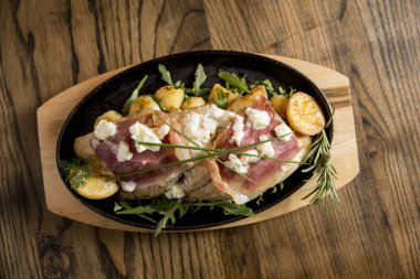 Krem peynirle doldurulmuş çipura ve füme jambon. Tabakta da taze patates ve pırasa var.