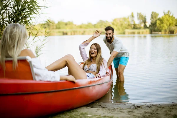 Hombre Joven Guapo Tirando Canoa Con Dos Mujeres Jóvenes Lago — Foto de Stock