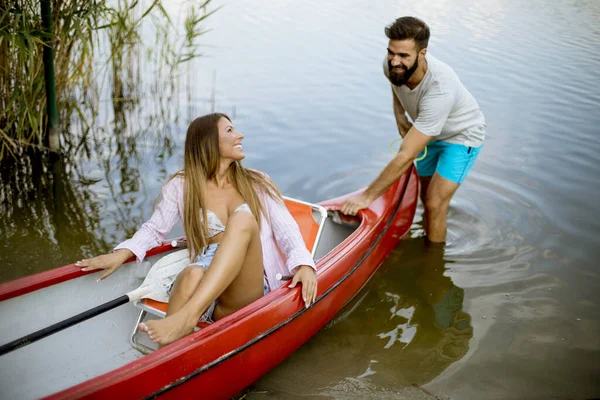 Bonito Jovem Puxando Canoa Com Jovem Mulher Lago Calmo — Fotografia de Stock