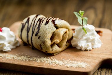 Tahta tabakta taze yapılmış krep rulosu.