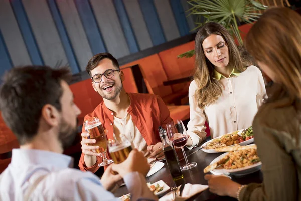 Group of young people having dinner in the restaurant