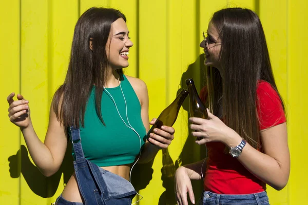 緑の壁に対して幸せな顔を持つ若い女性はヘッドフォンで音楽を聞き 楽しみを持っています — ストック写真