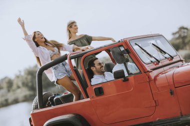 Bir grup mutlu genç yolculuğun tadını çıkarıyor.