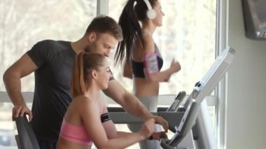 Spor salonunda bisiklet makinesinde güzel bir bayanla kişisel antrenör.