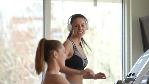Modern spor salonunda koşu bandı kullanan güzel genç bir kadın. — Stok video