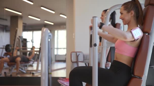 Mladá žena cvičení na hrudi na stroji v tělocvičně — Stock video