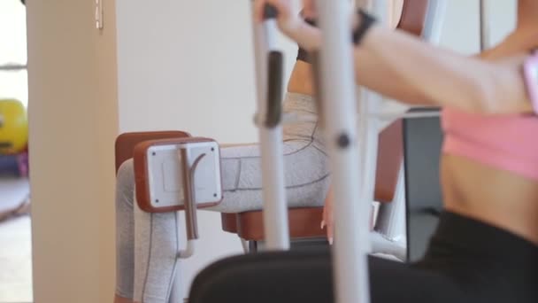 Mujer joven haciendo ejercicio en el pecho en una máquina en el gimnasio — Vídeos de Stock