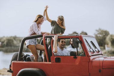 Bir grup mutlu genç yolculuğun tadını çıkarıyor.