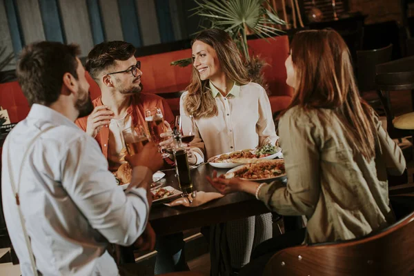 Bir grup genç restoranda yemek yiyor.