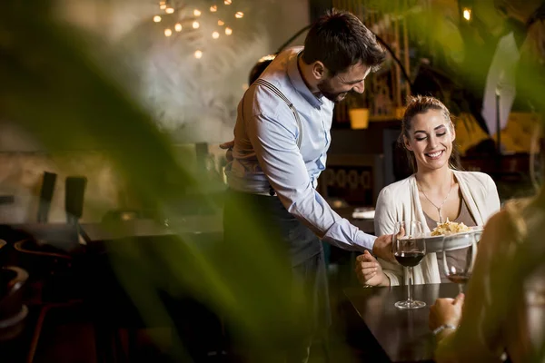 Dos Jóvenes Amigas Sonrientes Restaurante Con Camarero Sirviendo Cena — Foto de Stock